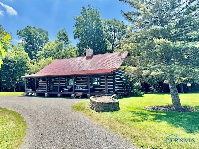 3190 Rd 204, Antwerp, OH 45813 - view of front of property featuring a chimney, a front yard, a metal roof, log exterior, and a porch