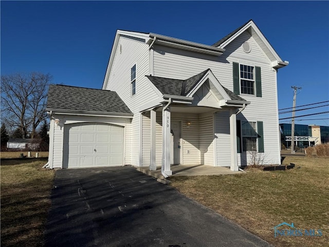 traditional home with a front lawn, roof with shingles, an attached garage, and aphalt driveway