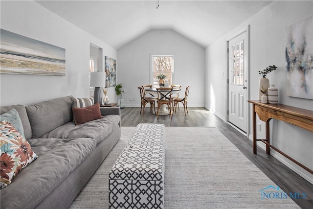 living room featuring baseboards, vaulted ceiling, and dark wood-type flooring