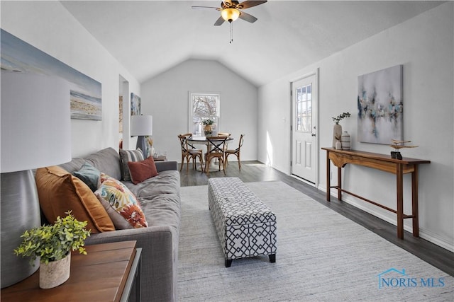 living room with dark wood-type flooring, vaulted ceiling, and a ceiling fan