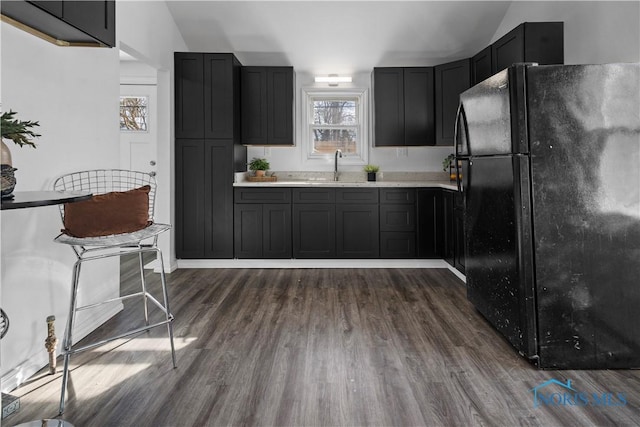 kitchen featuring dark wood-style floors, freestanding refrigerator, light countertops, and dark cabinetry