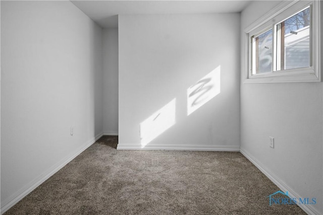 carpeted empty room featuring baseboards