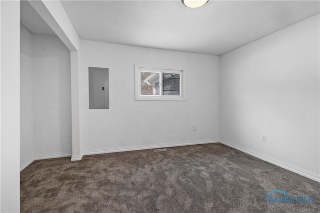 empty room with dark colored carpet, electric panel, and baseboards