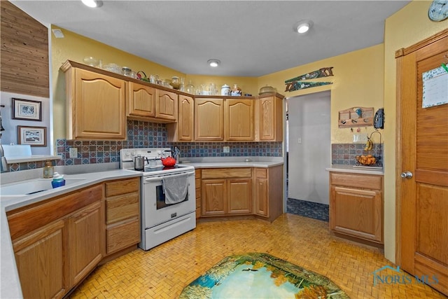 kitchen with white range with electric cooktop, recessed lighting, light countertops, backsplash, and a sink