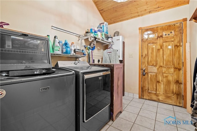 washroom featuring laundry area, washer and clothes dryer, light tile patterned flooring, and wooden ceiling