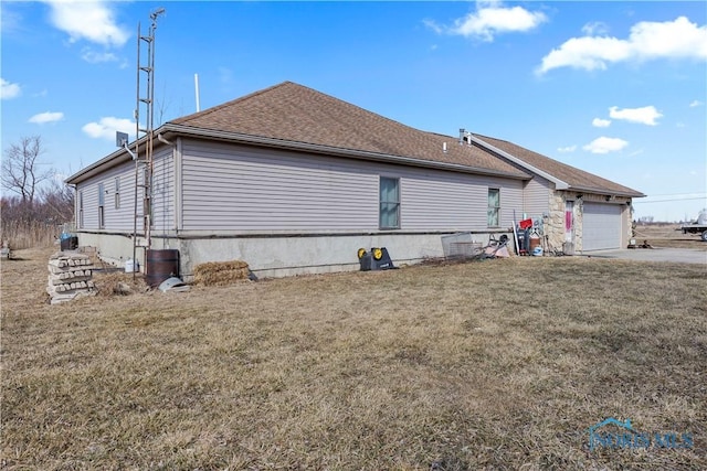 view of home's exterior featuring an attached garage, a lawn, and roof with shingles