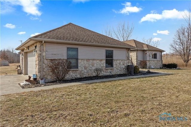 view of front of property featuring roof with shingles, concrete driveway, an attached garage, a front yard, and stone siding