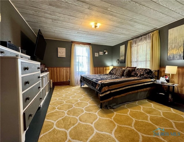 bedroom featuring wood ceiling, a wainscoted wall, and wood walls