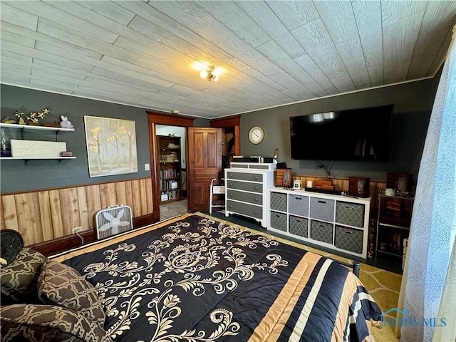 bedroom featuring a wainscoted wall, wood walls, and wooden ceiling