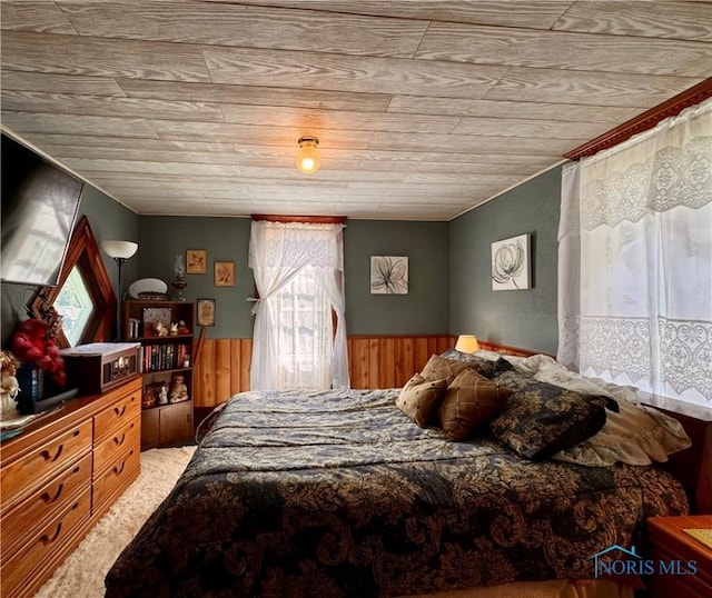 bedroom with wainscoting and wooden walls