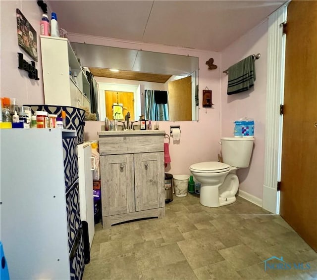 bathroom with toilet, baseboards, and vanity