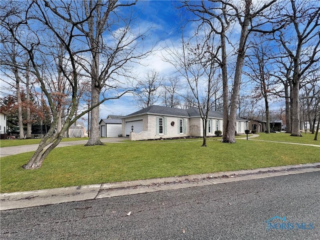 view of front of property with a garage, brick siding, driveway, and a front yard