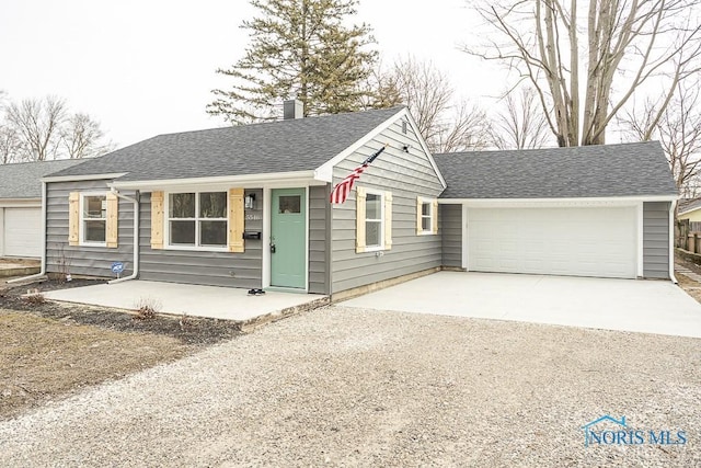 ranch-style house with driveway, an attached garage, and roof with shingles