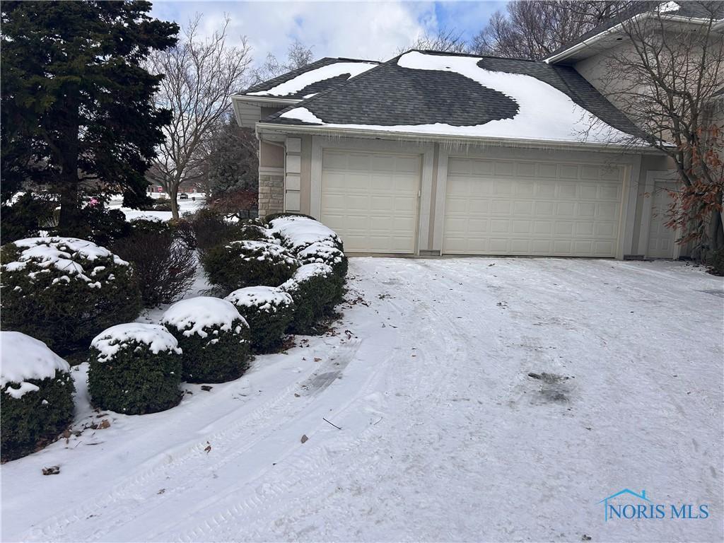 snow covered garage featuring a garage