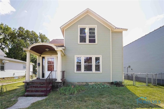 traditional-style house with a front yard and fence