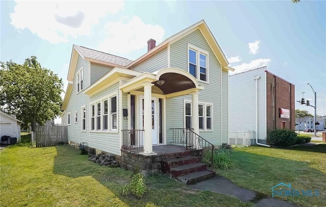 traditional home with a shingled roof, fence, a chimney, and a front lawn