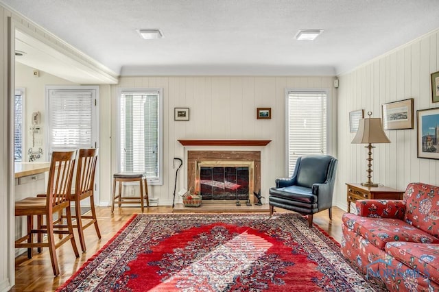 living room featuring a glass covered fireplace and baseboards