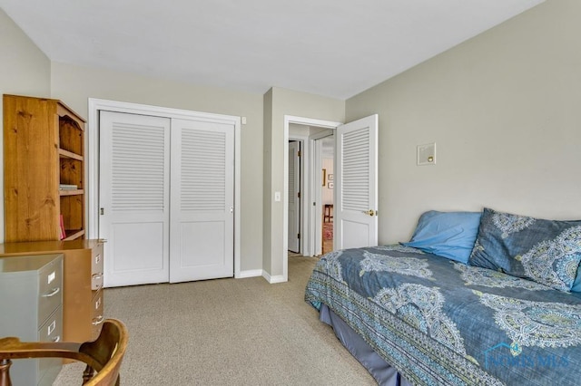 carpeted bedroom with a closet and baseboards