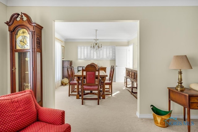 dining space with light carpet, ornamental molding, and a notable chandelier