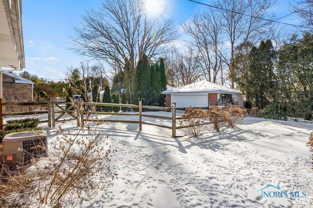 snowy yard with an outbuilding, central AC, and fence