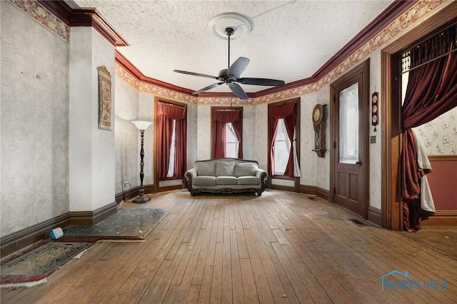 foyer entrance featuring ornamental molding, wood-type flooring, and a textured ceiling