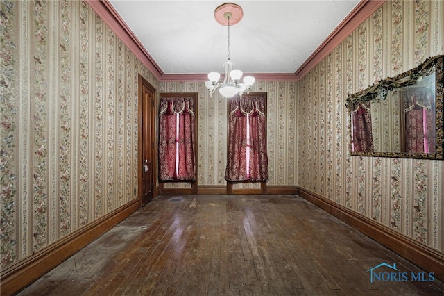 unfurnished dining area with wallpapered walls, baseboards, ornamental molding, and hardwood / wood-style flooring