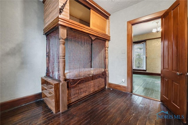 interior space with hardwood / wood-style flooring, baseboards, and a textured ceiling