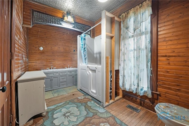 interior space with an ornate ceiling, wooden walls, visible vents, and gray cabinets