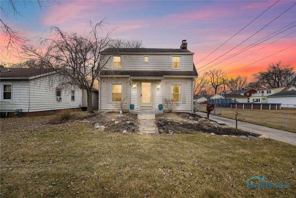 2939 W Alexis Rd, Toledo, OH 43613 - view of front facade featuring a chimney, fence, and a yard