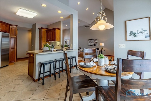 dining space with light tile patterned floors, vaulted ceiling, visible vents, and recessed lighting