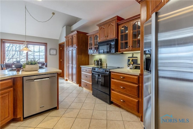 kitchen with brown cabinets, light tile patterned floors, light countertops, glass insert cabinets, and black appliances