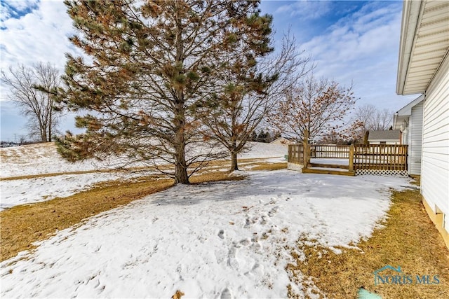 yard covered in snow featuring a deck