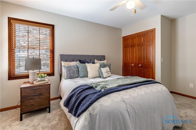 bedroom with light carpet, ceiling fan, baseboards, and a closet