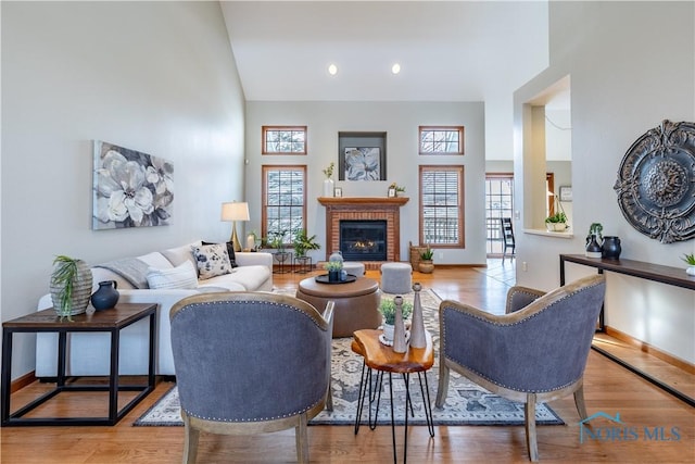 living room featuring a wealth of natural light, a high ceiling, and light wood-style flooring