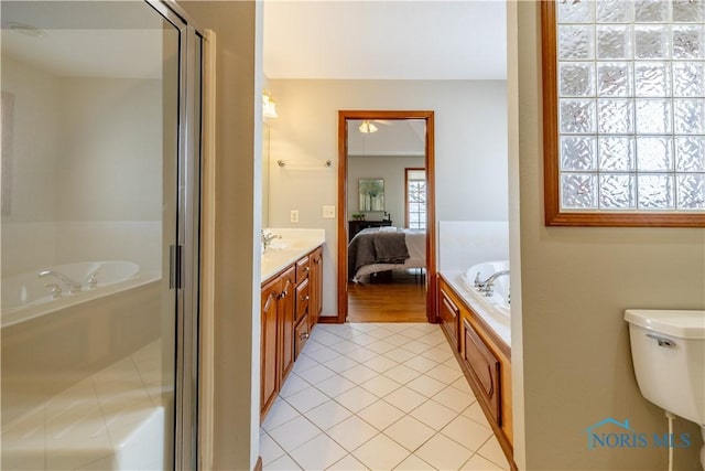 ensuite bathroom with a bath, connected bathroom, vanity, and tile patterned floors