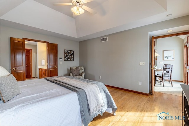 bedroom with lofted ceiling, light wood finished floors, and baseboards