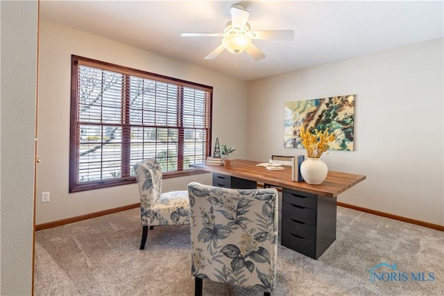 office featuring light colored carpet, ceiling fan, and baseboards