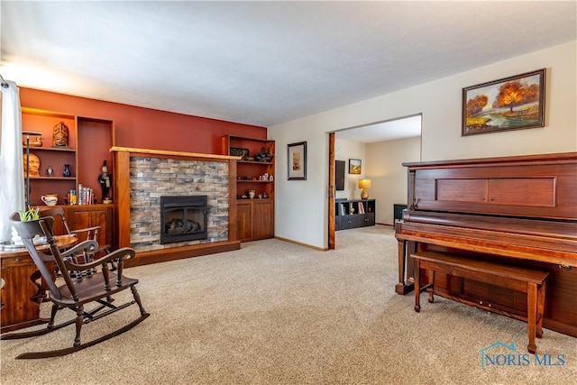 living area with a fireplace, baseboards, and light colored carpet