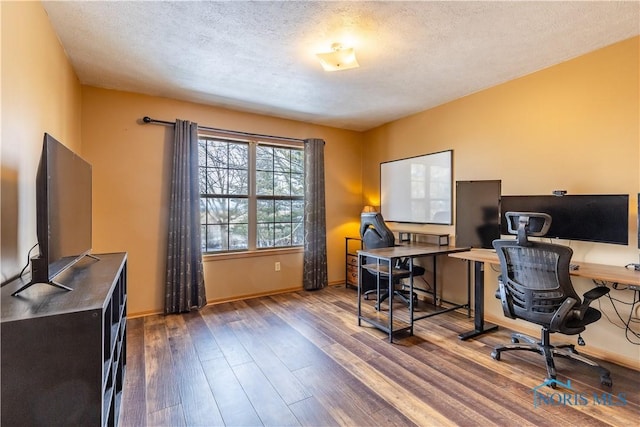 home office featuring a textured ceiling, wood finished floors, and baseboards