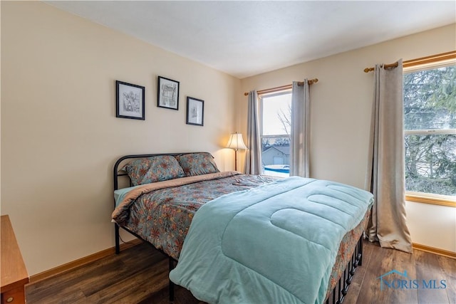 bedroom featuring multiple windows, dark wood finished floors, and baseboards