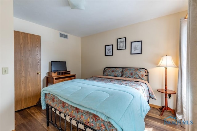 bedroom featuring wood finished floors and visible vents