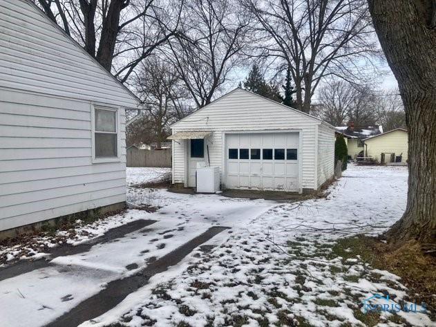 snow covered garage with a garage