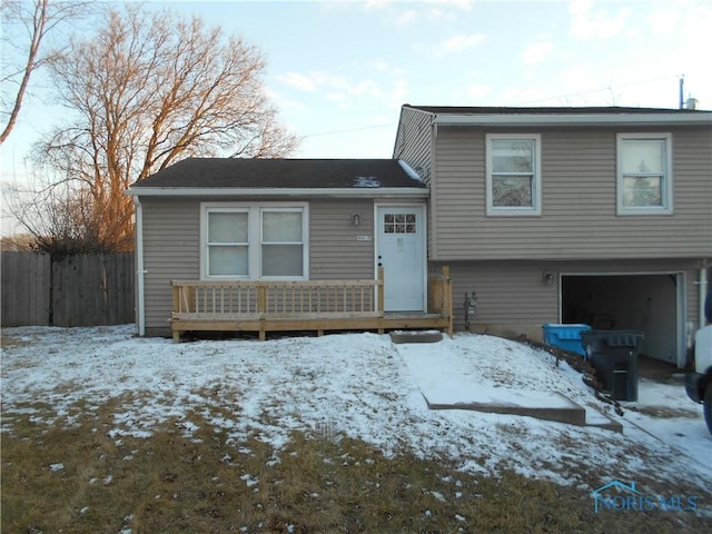 tri-level home featuring a garage and fence