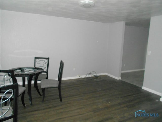 dining space with baseboards and dark wood-type flooring