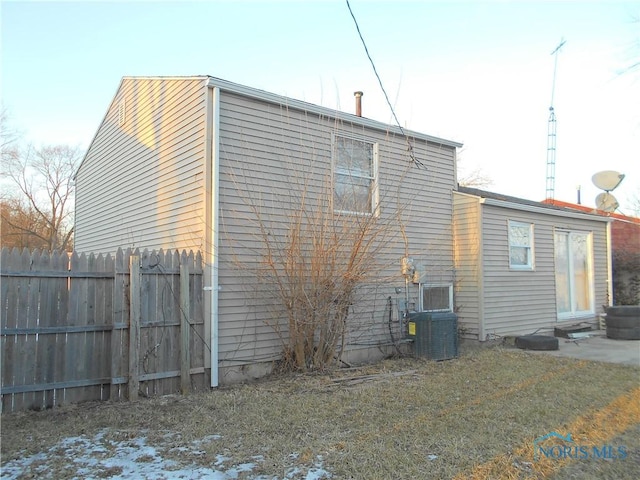 back of house with fence, cooling unit, and a yard