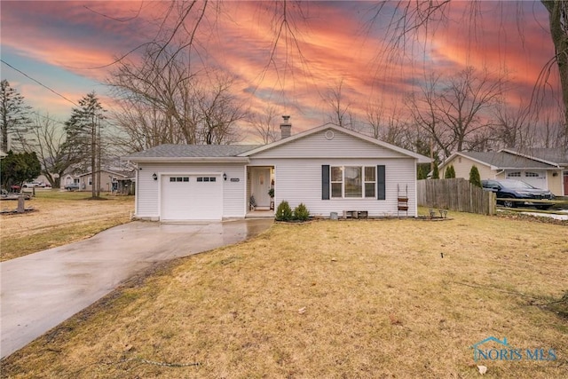 view of front of house featuring a yard, a chimney, concrete driveway, an attached garage, and fence