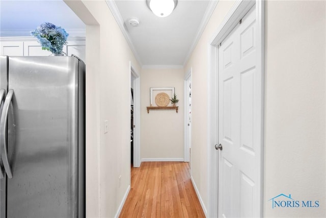 hallway with light wood-type flooring, baseboards, and ornamental molding