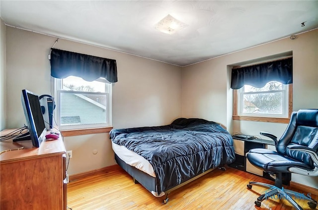 bedroom with light wood-style floors and baseboards