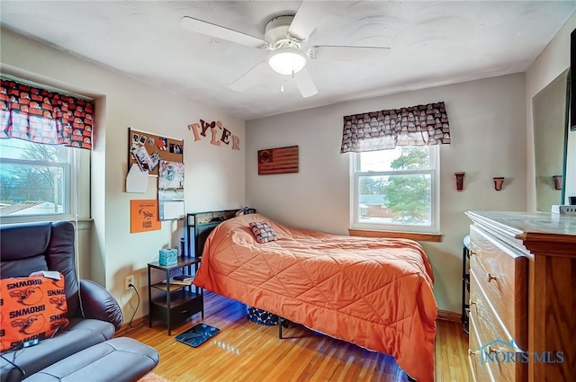 bedroom featuring light wood finished floors, baseboards, and a ceiling fan