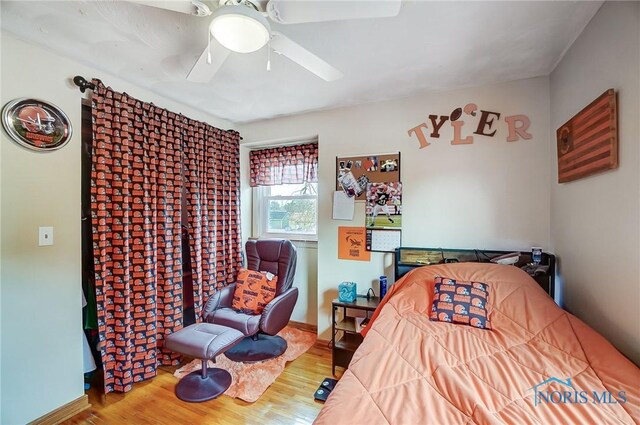 bedroom featuring ceiling fan, wood finished floors, and baseboards